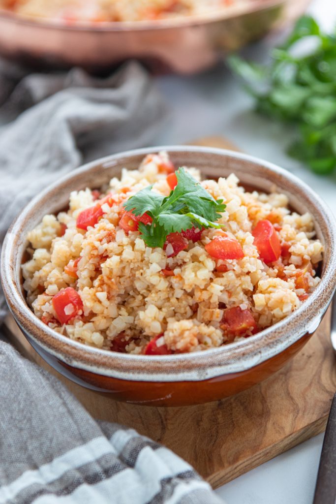 Cauliflower rice and Mexican seasonings transform plain cauliflower rice into a savory keto Mexican rice. This low fat, low calorie, low carb, and dairy free side dish pairs perfectly with your tacos, enchiladas, or bowls.