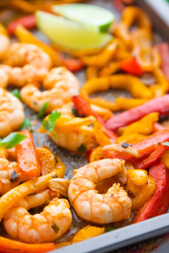Close up of keto chili lime shrimp and peppers on a sheet pan.
