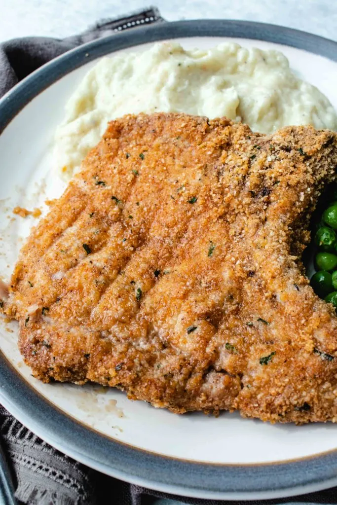 If you're in the market for a homestyle keto meal to feed your family, look no further. Keto pork chops are coated in a seasoned low carb breading and baked in an oven until crisp and tender. The ultimate family friendly keto supper!
