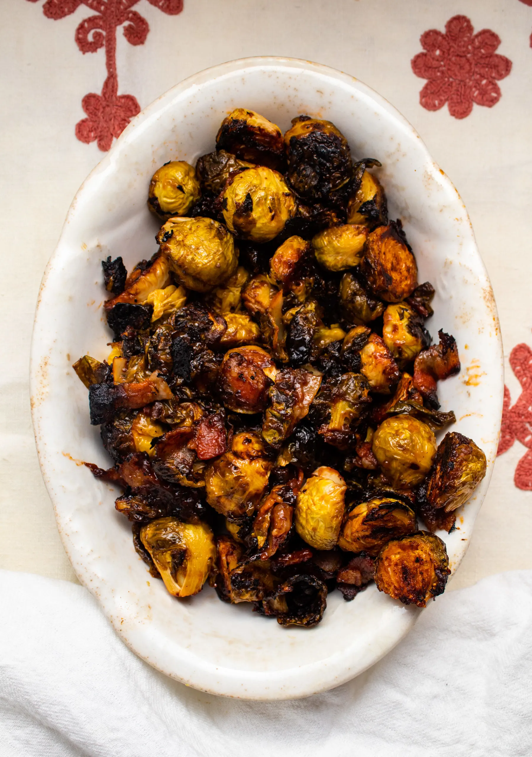 Brussel sprouts are roasted in the oven with bacon and a bbq glaze until crisp and caramelized. Learn how to make the best crispy bacon brussel sprouts.