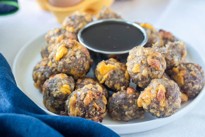 Keto sausage balls with egg, cheese, and maple syrup are a great on the go low carb breakfast.