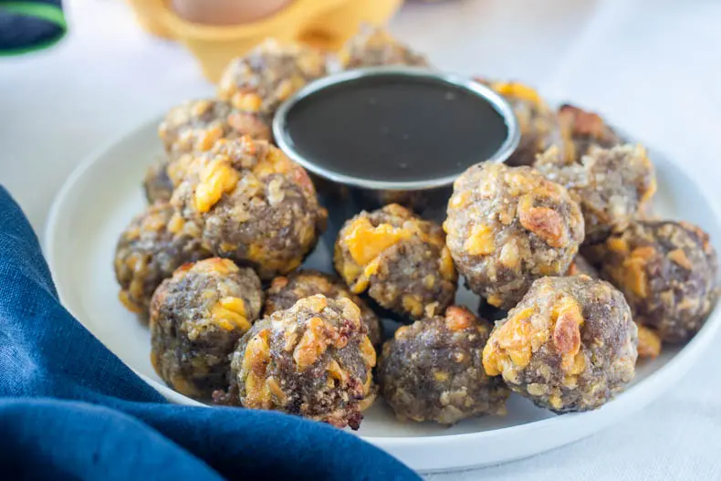 Keto sausage balls with egg, cheese, and maple syrup are a great on the go low carb breakfast.